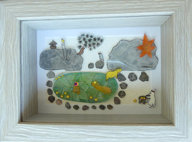 Collage of small, flat sculptural elements depicting a scene of many capybaras at an onsen with floating yuzu fruit. Piece is within a shadow box.