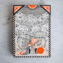 Fine line black ink drawing with bright orange color accents, of a cat and a fox, dressed as people standing in the woods under large trees. One holds a large net and has an orange sun under its arm. The other, holds a large open sack of orange stars.