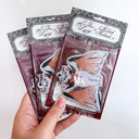 Air freshener with a cat wearing a cape in a package. 