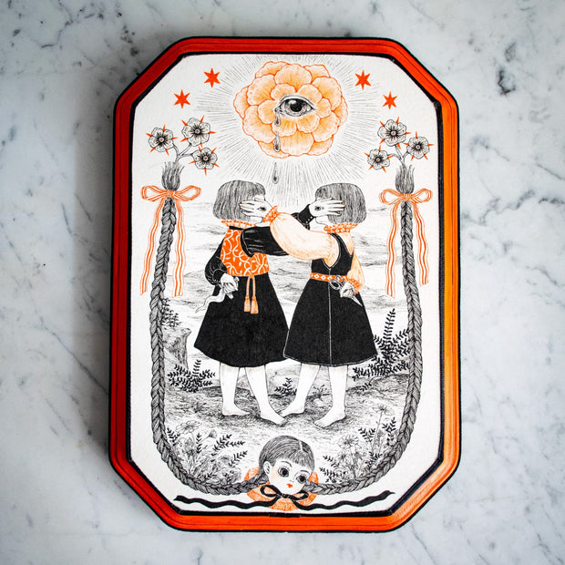 Black ink illustration with subtle orange coloring of 2 small girls in black dresses, with one hand on the other's face. The back of their hands have an eye on them. A doll head with long braids is at the bottom of the piece, with the braids framing the scene.