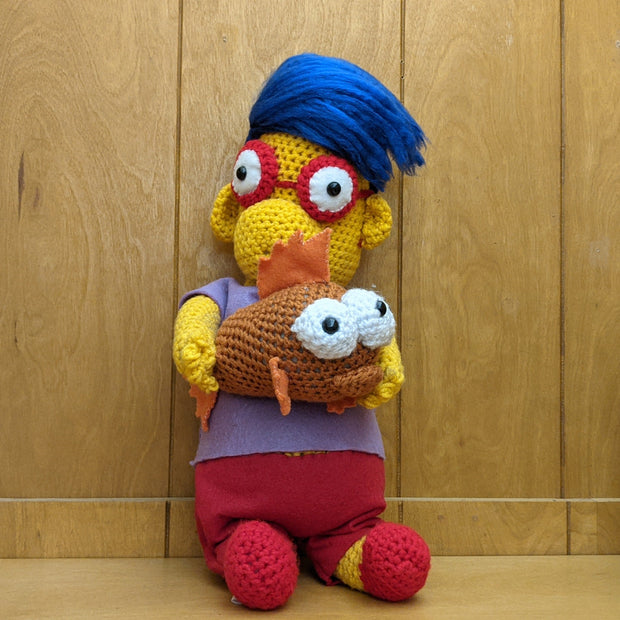 Crocheted sculpture of Millhouse from The Simpsons holding Blinky the three eyed fish. 
