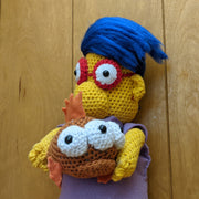 Crocheted sculpture of Millhouse from The Simpsons holding Blinky the three eyed fish.