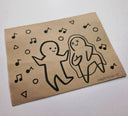Cartoon-style drawing of a couple with musical notes on brown paper, signed 'Paper Robot'.