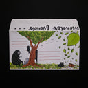 Illustration on a paper envelope of a tree with various characters and cats around.
