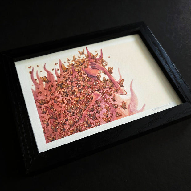 Framed artwork of red devil character emerging from flames with dozens of butterflies surrounding them