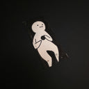 A small rectangular black-and-white drawing featuring a minimalist cartoon figure, photographed on a dark black background.