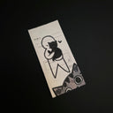 A rectangular drawing of a black line drawing of a cat and heart, photographed on a dark black background.