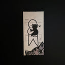 A rectangular drawing of a black line drawing of a cat and heart, photographed on a dark black background.