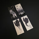 Set of 4 black ink illustrations on thin white strips of paper of a simplistic white character in scary situations.