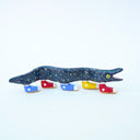 Ceramic sculpture of a blue eel with small, colorful polkadots and an open mouth with tiny teeth. The eel has 5 feet, all wearing sneakers either blue, red or yellow.