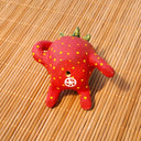 Small ceramic sculpture of a strawberry, with green leaves, yellow spots for its seeds and 3 eyes. It has 2 mouths, one is smiling and the other is a surprised "o". It sits with one arm balancing it and the other behind its head.