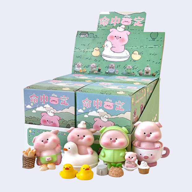 4 figurines designed as happy, chubby pigs with accessories. Options are: Apron wearing pig with baked goods, Pig in duck circle floaty with rubber ducks, Gardner pig in green raincoat and Teacup pig with cupcake.
