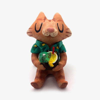Sculpture of a cartoon style orange tabby cat, sitting with its legs out in front and eyes closed. It holds a pińa colada in its paws and wears a Hawaiian shirt.