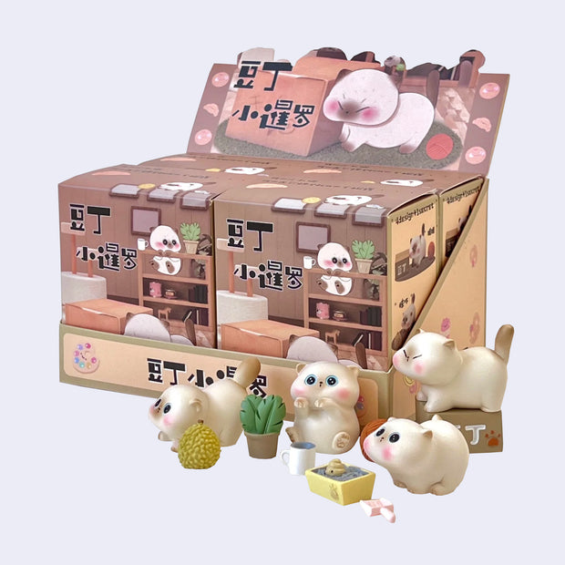 4 small cute, siamese cat figures with different accessories. They all stand near their product packaging.