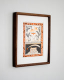 Artwork of 2 whimsical illustrated kittens holding flower stems, mountains in the background and an orange bird flying between them. Below them is a separate drawn panel of a house with an overgrown garden and a star flying overhead. Piece is framed in a wooden frame.