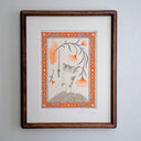 A whimsical illustration of a gray and white kitten standing on a textured mound, holding a very thin sword, with large orange flower stems overhead. The print is enclosed in an ornate orange, white, and gray decorative border on a light gray background. Piece is housed in a wooden frame.