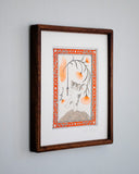 A whimsical illustration of a gray and white kitten standing on a textured mound, holding a very thin sword, with large orange flower stems overhead. The print is enclosed in an ornate orange, white, and gray decorative border on a light gray background. Piece is housed in a wooden frame.