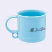 Back of small blue plastic cup with colorful writing in Japanese and small bubbles.