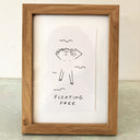 Ink illustration of a simple figure, partially drawn and partially left blank floating on their back in water with text that reads "floating free"