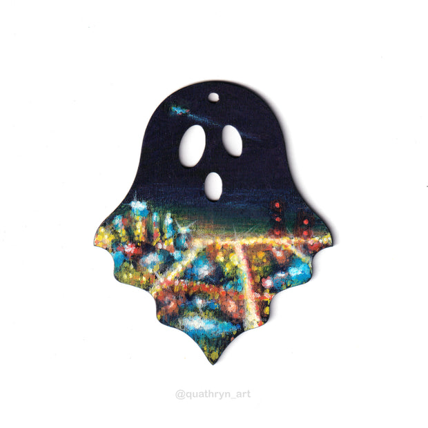 Ghost shaped wood panel with an illustration of a cityscape at night, seen from afar so it is a grid of glowing lights. A plane is seen in the dark night sky.