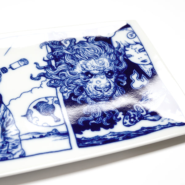 Rectangular white porcelain plate with dark blue line art illustrations of 2 scenes, divided like a comic panel. Left scene depicts a person with long hair and robotics coming out of their head. A dragon flies down behind them. Right scene is of a lion head, with a fierce mane and the solemn face of a girl. Showing detail.