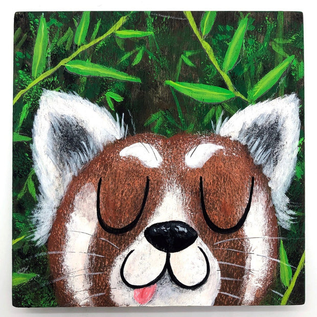 Illustrative style painting of a cute, red panda with large closed eyes and a smiling tongue out expression. Only its head is visible but it takes up most of the surface, with bamboo behind it.