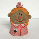 Ceramic sculpture of a girl's top half, without arms. She wears a pink cowgirl style button up and a tiny pink cowgirl hat with a star.