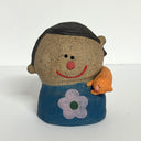 Ceramic sculpture of a boy's top half, without arms. He wears a blue shirt with a flower design. Wrapped around his shoulder is an orange cat.
