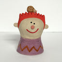 Ceramic sculpture of a boy's top half, without arms. He wears a pink shirt with a brown zig zag design. He has spiked orange hair and atop his head is a small hedgehog.