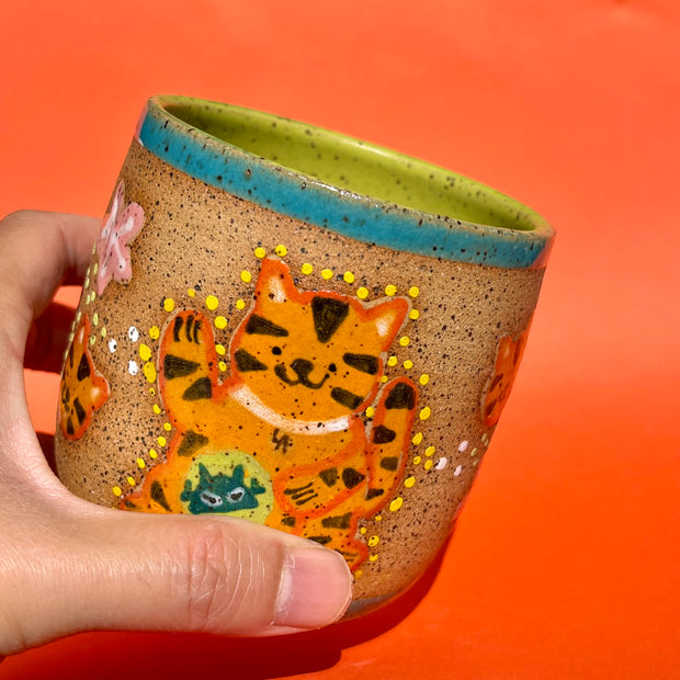 Earthenware ceramic pot with cartoon style illustrations of a tiger on the front, decorated with small robot heads and cherry blossoms.