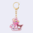 Die cut acrylic charm attached to gold ware keychain. Charm features an illustration of My Melody and Kuromi sitting next to a large strawberry sundae.