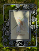 Illustration of a small flower fairy, standing in a side profile view and holding a large white flower on its stem.