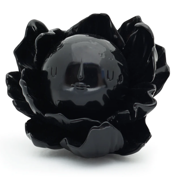 Moonflower toy by yoskay Yamamoto is black flower with a removable moon with a face in it that's the middle of the flower. It's all black.