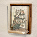 Mixed media sculpture of a person sitting on the branch of a tree, playing a sound bowl with small owls around them.