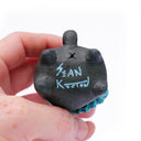 View of the bottom of a cat sculpture with artist signature.