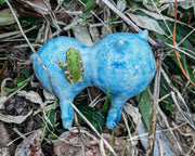 Small blue and white splotched ceramic sculpture of a character made up of 2 spheres attached together, with 4 legs and small ears and eyes.