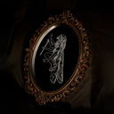 An ornate oval wall mirror with a carved, scrollwork bronze-brown frame, reflecting a black background with a white line-art illustration of a winged female figure.