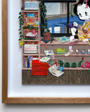 Paper cut sculpture of a cartoon character with a geisha's hairstyle. She sits on a window sill looking out of a city bridge. She is surrounded by shelves full of Japanese and Giant Robot themed trinkets.