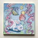 A square watercolor painting featuring a white rabbit on a blue platform, a yellow and black striped wasp, pink wavy lines, and yellow and red flowers against a light blue and green background, mounted on a textured beige wall.