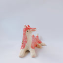 Ceramic figurine of a white and pink fox with 3 tails and patterned fur. It has red "wind" designs on it and gold painted accents.