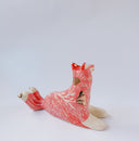 Ceramic figurine of a white and pink fox with 3 tails and patterned fur. It has red "wind" designs on it and gold painted accents.