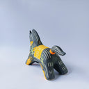 Black matte ceramic figure of a horse with carved decorative elements of orange poppy flowers, orange flames and an orange blanket. It has an orange tassel in its mouth.