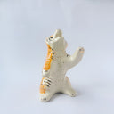 Glossy ceramic sculpture of a white and orange tiger, leaning back on its hindlegs with its front legs up and its head thrown back. It has an orange poppy flower pattern on its back.