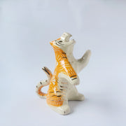 Glossy ceramic sculpture of a white and orange tiger, leaning back on its hindlegs with its front legs up and its head thrown back. It has an orange poppy flower pattern on its back.