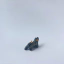 Very small black sgraffito ceramic sculpture of a tiger, with a long body and a carved pattern of orange poppy flowers.