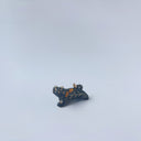 Very small black sgraffito ceramic sculpture of a tiger, with a long body and a carved pattern of orange poppy flowers.