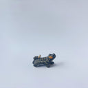 Very small black sgraffito ceramic sculpture of a tiger, with a long body and a carved pattern of orange poppy flowers.