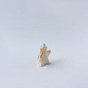 Very small ceramic sculpture of a white and orange tiger, leaning back on its hindlegs with its front legs up and its head thrown back.