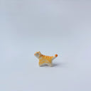 Very small ceramic sculpture of an orange and white tiger with gold detailing,