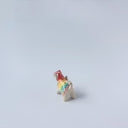 Very small ceramic sculpture of a tiger with a white underbelly and rainbow coloring on its back with gold detailing.